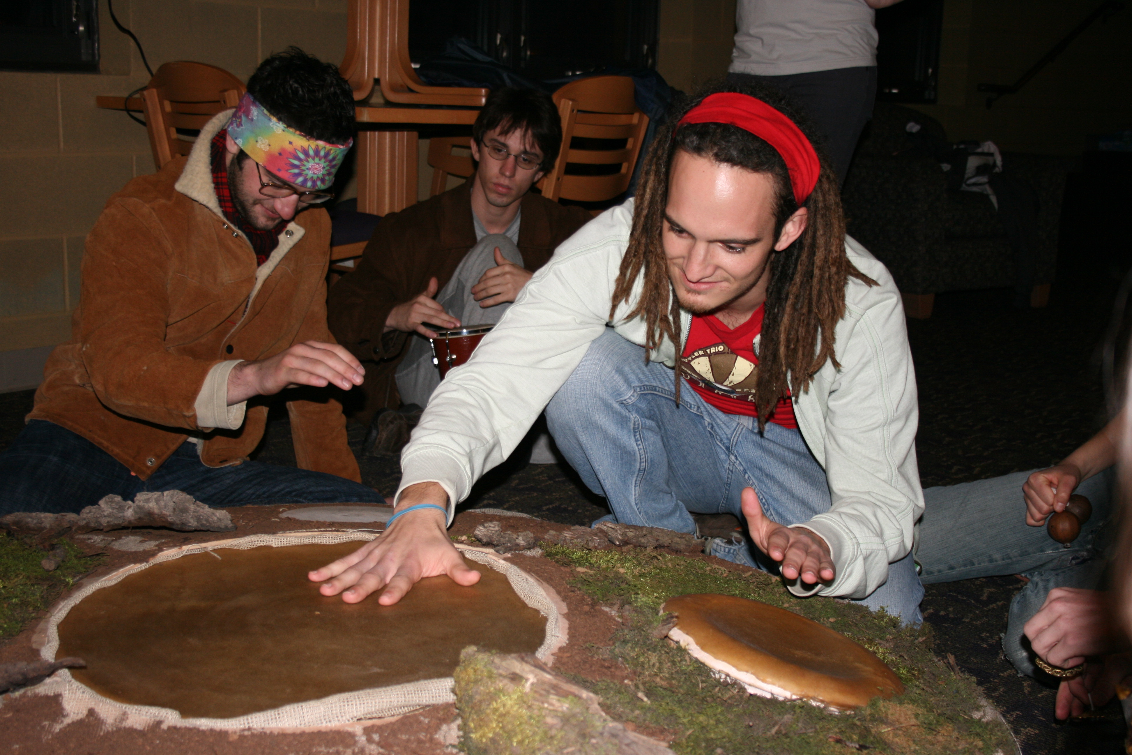 earth-hourchase-snyder Benito Miller bangs on a drum circle made by Alex Troyer during the hour of darkness known as Earth Hour. The drumming and noisemaking grew to thunderous proportions when the lights went out at 8:30, Saturday. Photo by Chase Snyder.