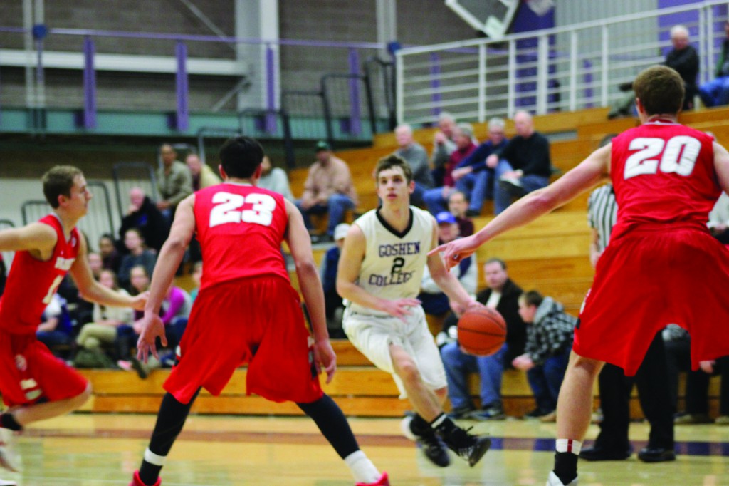 Billy Geschke, a first-year, dribbles past Indiana Wesleyan opponents at Tuesday's game. Photo by Leah Stebly