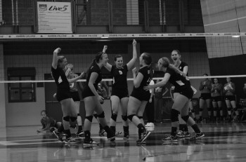Volleyball scholar athletes Sam Heberling, senior, Natalie Hubby, junior, and Kelsey Smith, junior, celebrate a point with the team
