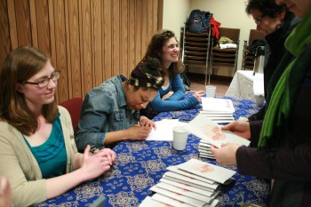 Kate Yoder, senior, Dominique Chew, senior, and Elizabeth Derstine, junior sign their books at the Pinchpenny release party.