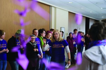 Abby Deaton, a senior, organizes supporting students near the Kairos cranes display at the Positive Purple Pep Rally last Friday.