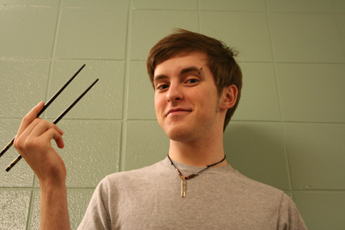 Lucas Nafziger holds chopsticks and poses for a picture