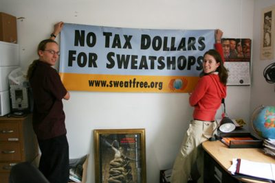 People hang up a sing that says "No tax dollars for sweatshops"