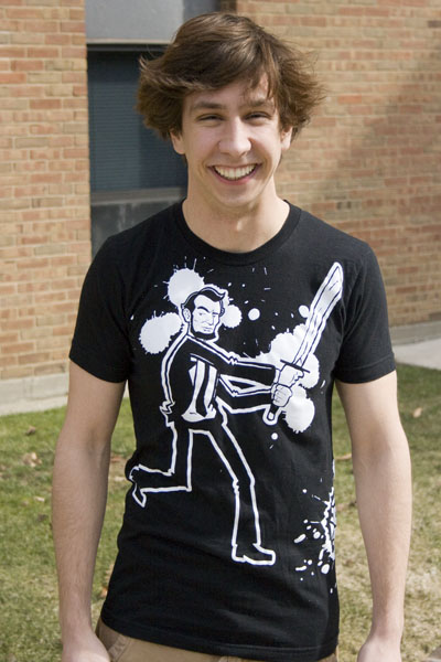 Jacob Schlabach smiles for the camera. He is wearing a T-shirt with a cartoon version of Abraham Lincoln holding a sword