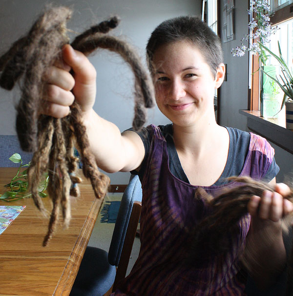 Annali Smucker holds up her dreadlocks after cutting her hair