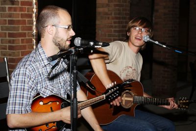 Zach Hawkins and Pete Nelson of Jayber Crow sing and play guitar and mandolin on the KMY lawn