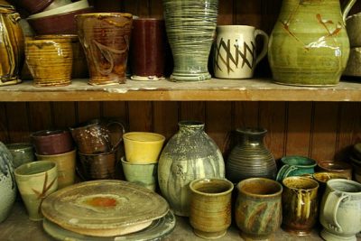 Shelves full of ceramic mugs, pitchers, and plates