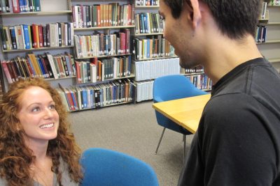 A student talks to a smiling transfer student in the Good Library