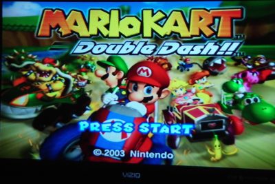 Photo of a TV screen displaying the video game "Mario Kart: Double Dash!!"