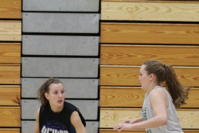 A player on the Goshen women's basketball team dribbles the ball away from an opposing player