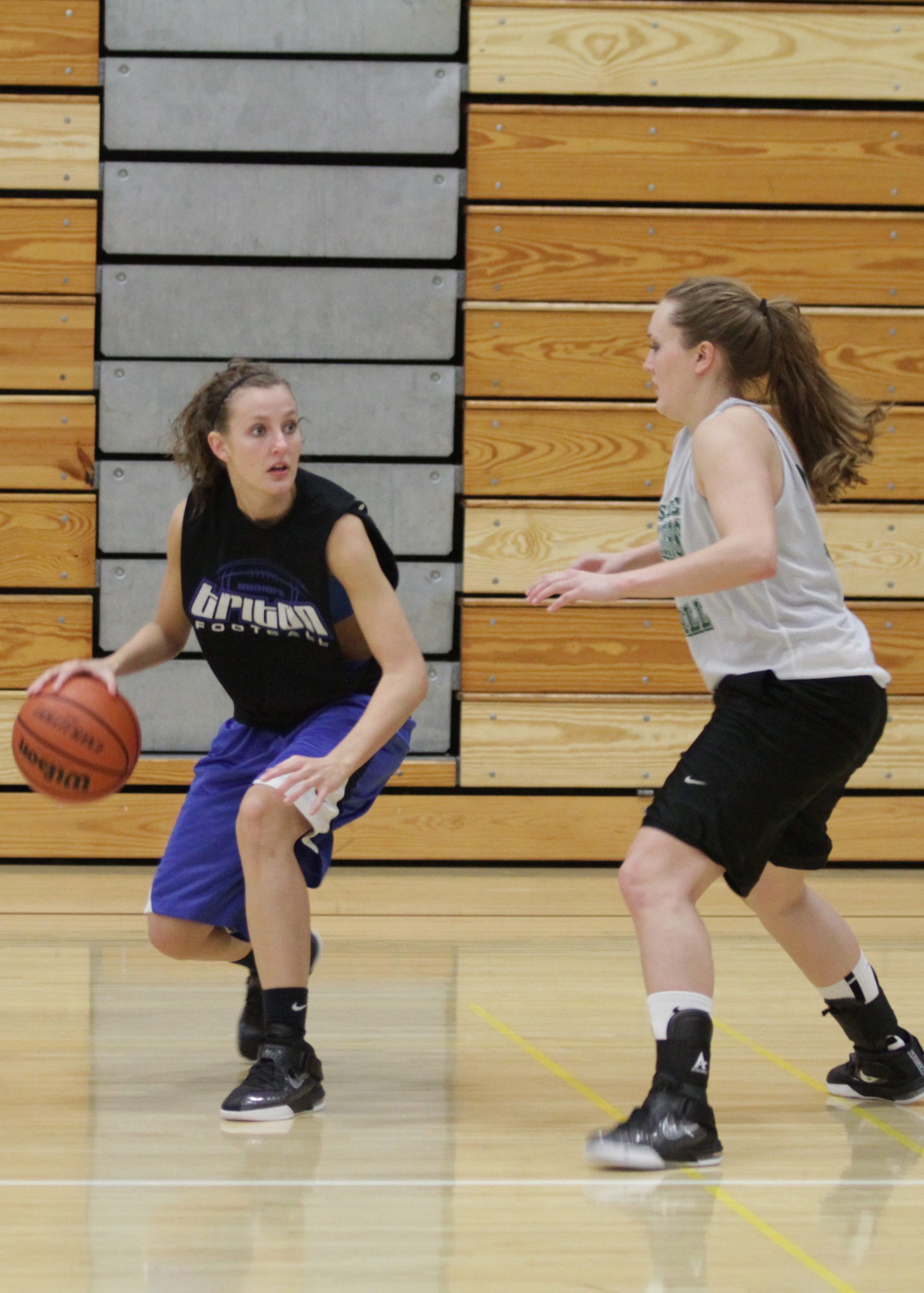 A player on the Goshen women's basketball team dribbles the ball away from an opposing player