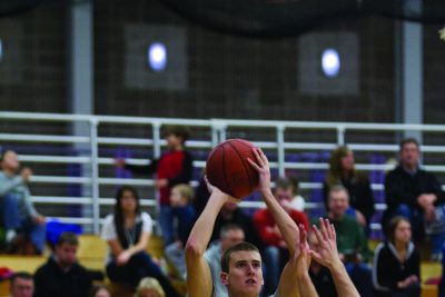 Garner Small prepares to shoot during a basketball game. The bleachers are full of spectators in the background