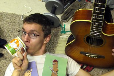 Phil Scott poses with his guitar and some of his drawings
