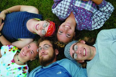 Students lay on grass heads together in Oregon