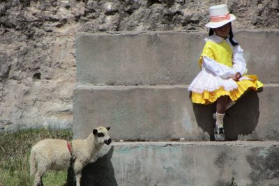 Josh Yoder's photo of a girl and a sheep outside a school in Peru