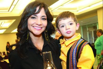Daniela Zehr holds her son Micah and smiles for the camera in the Fellowship Hall