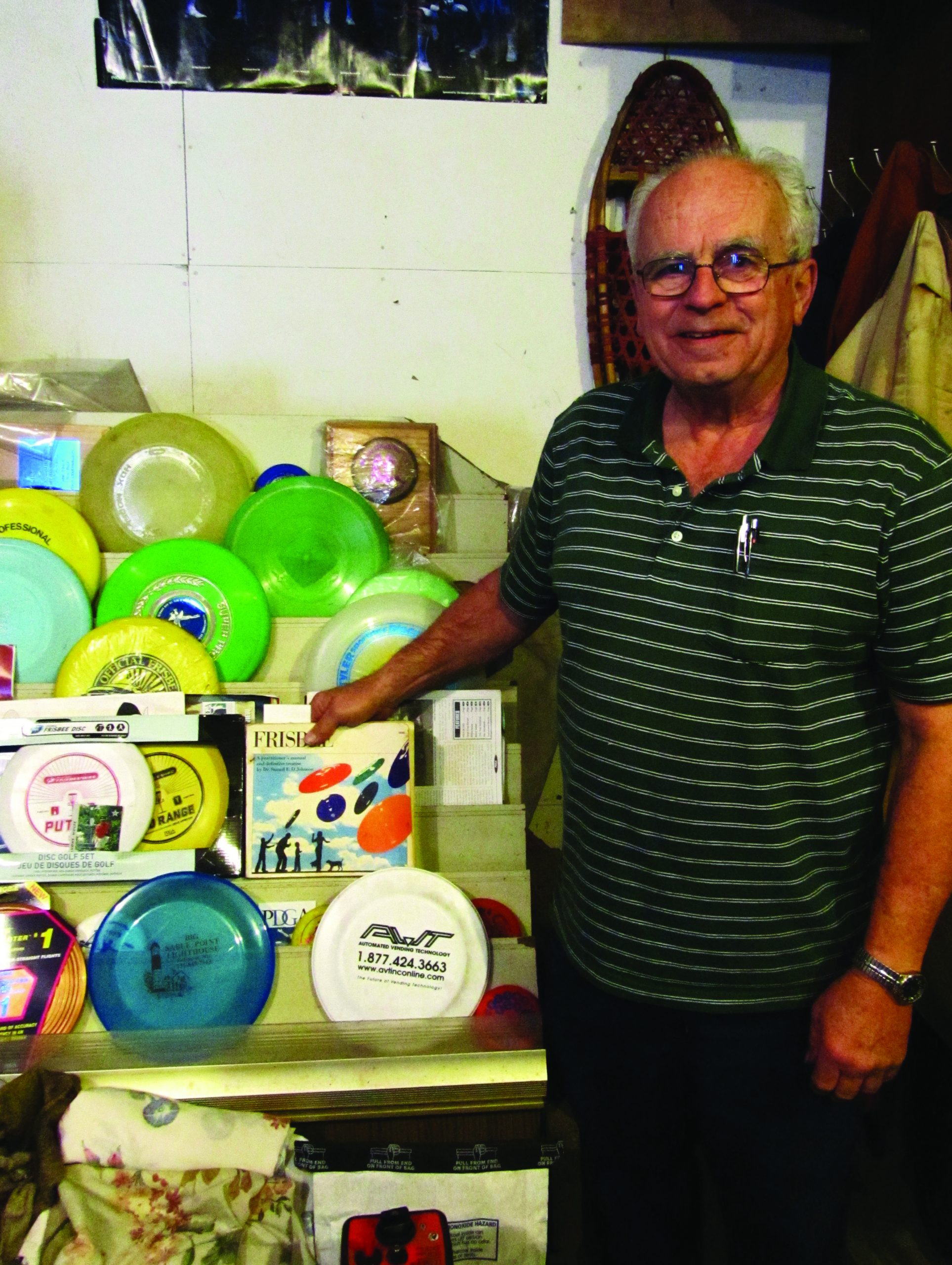 Jim Ingold stands next to his large Frisbee collection