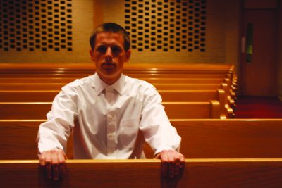 Daniel Penner sits in a pew in the Church Chapel
