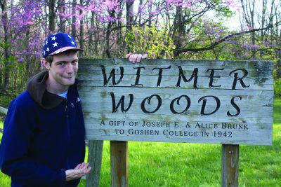 Daniel Penner stands next to a Witmer Woods sign