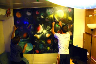 Aaron Bontrager and Jordan Weaver hang up a poster of outer space in their dorm room