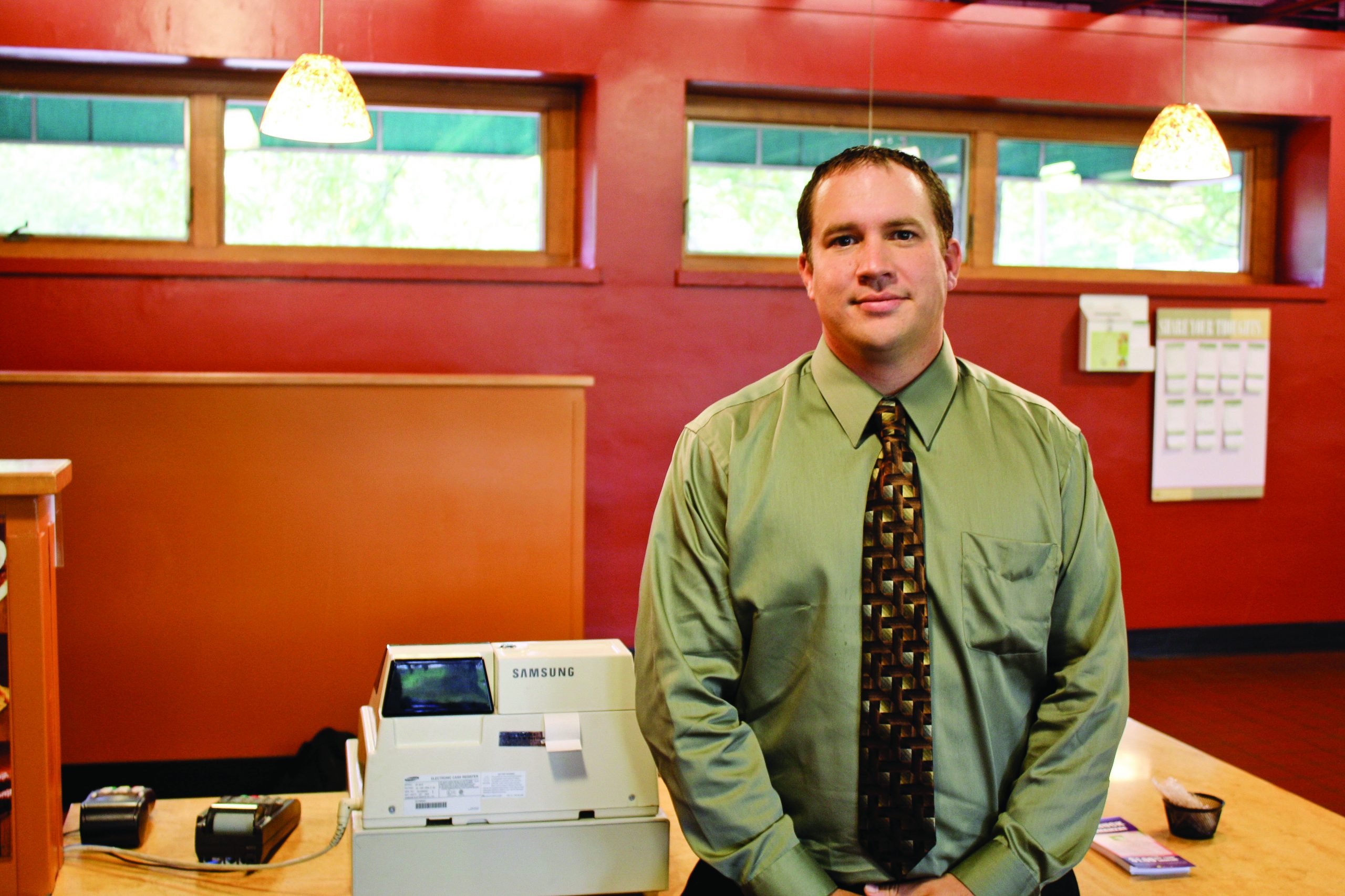 Garrett Tyk stands next to the cash register in Westlawn Dining Hall