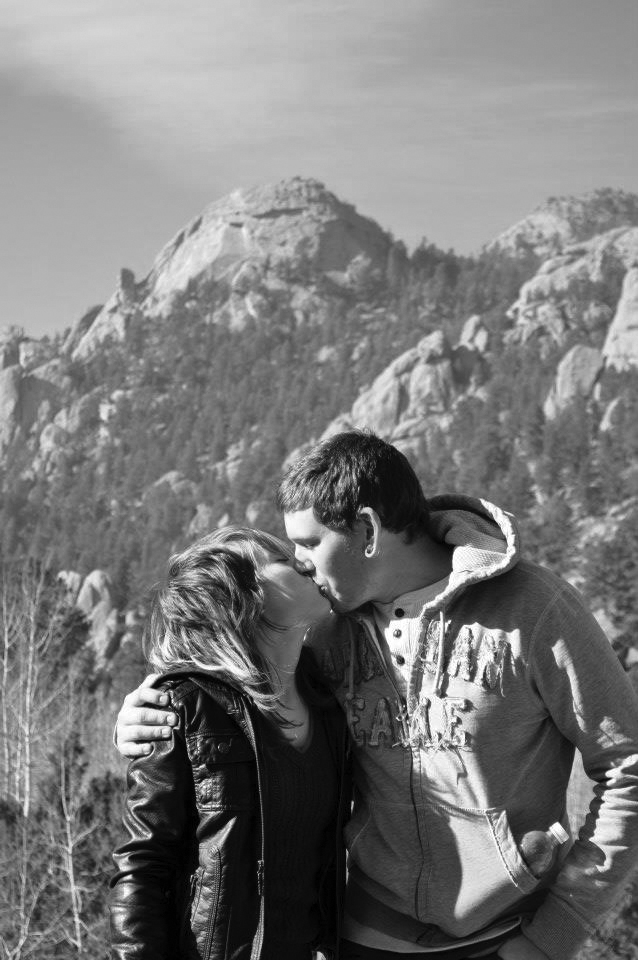 Black and white image of Kelley and her fiancee kissing below a mountain