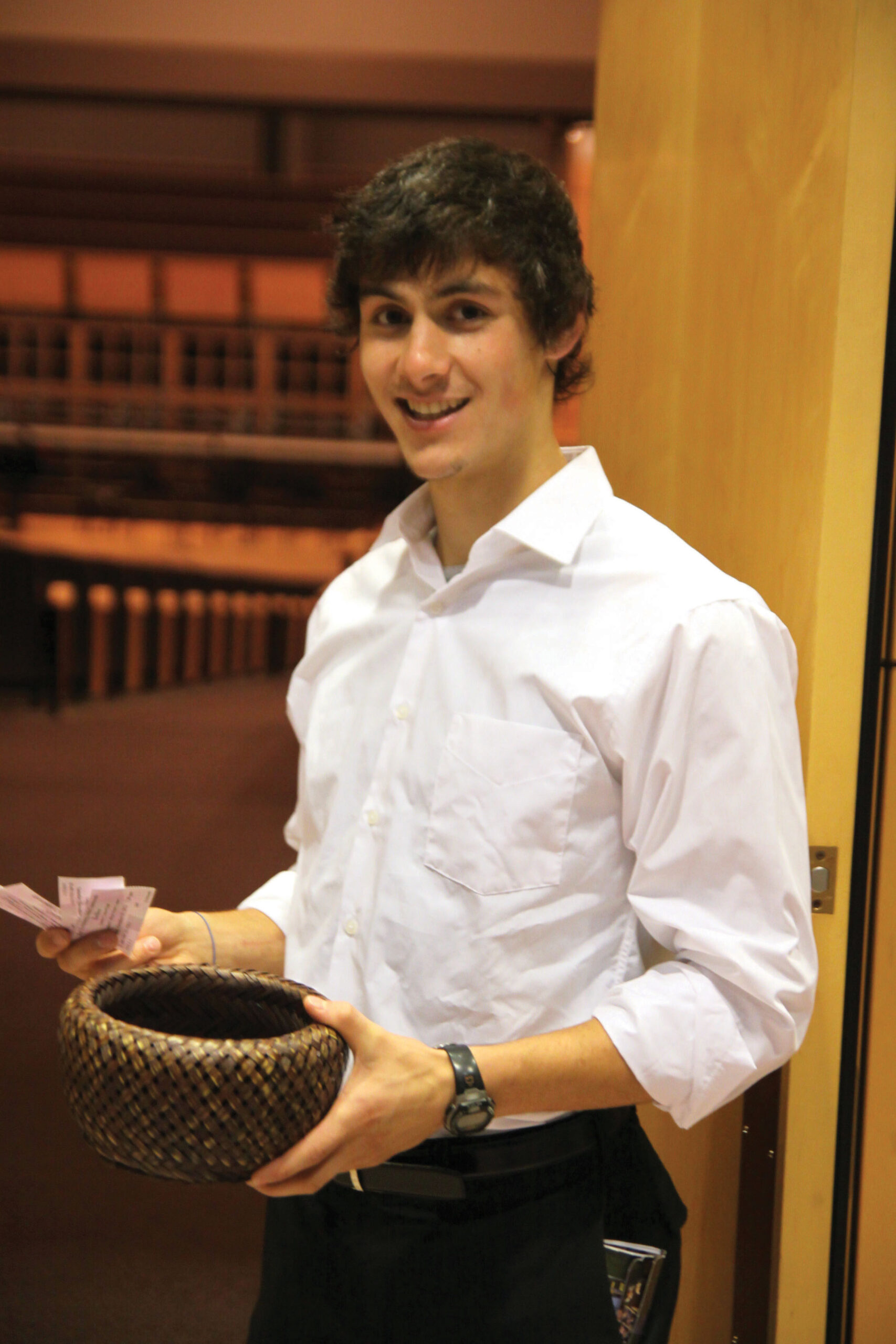 Student usher Lucas Harnish prepares to take patrons' tickets outside Sauder Concert Hall
