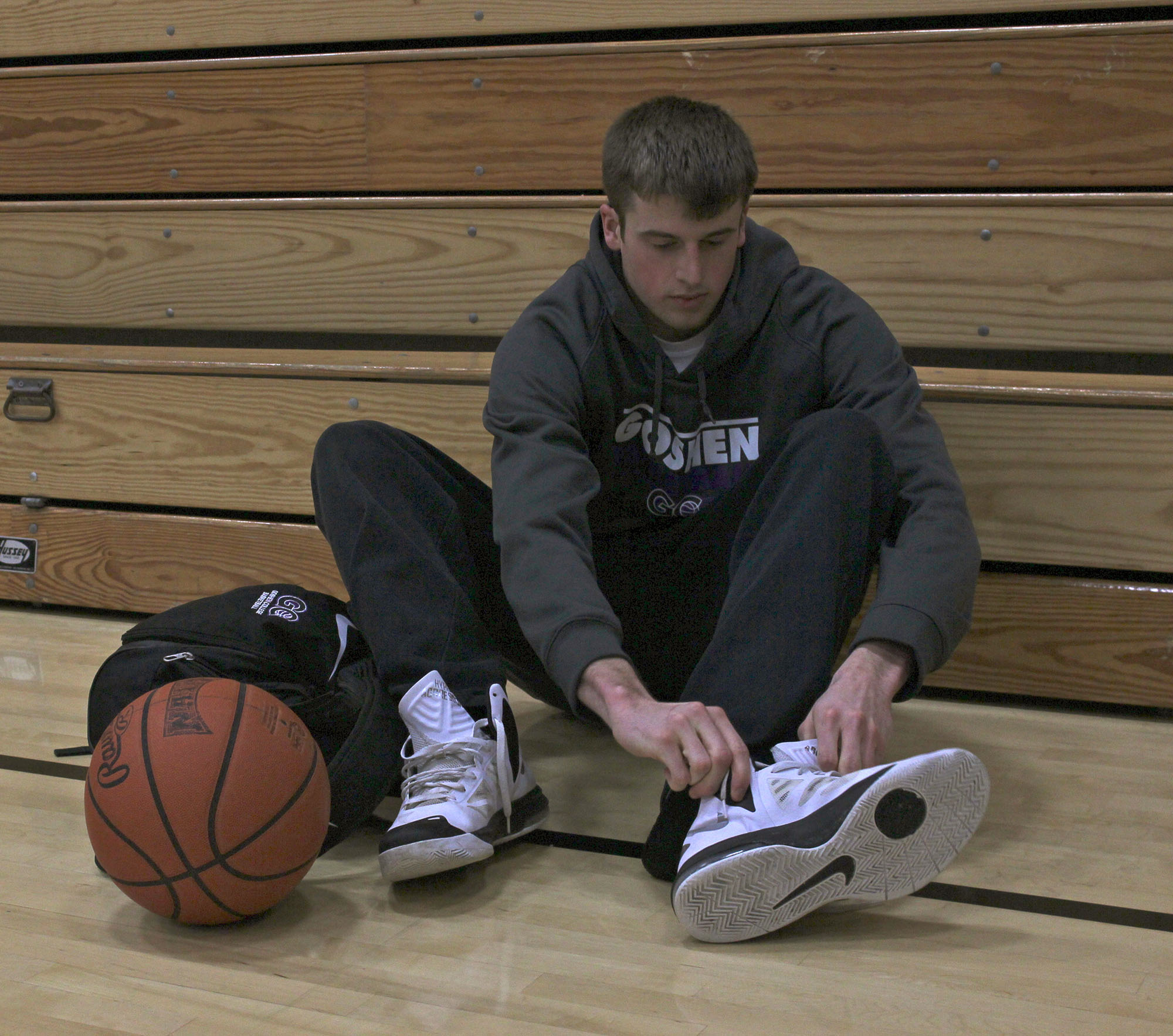 basketball player putting shoes on