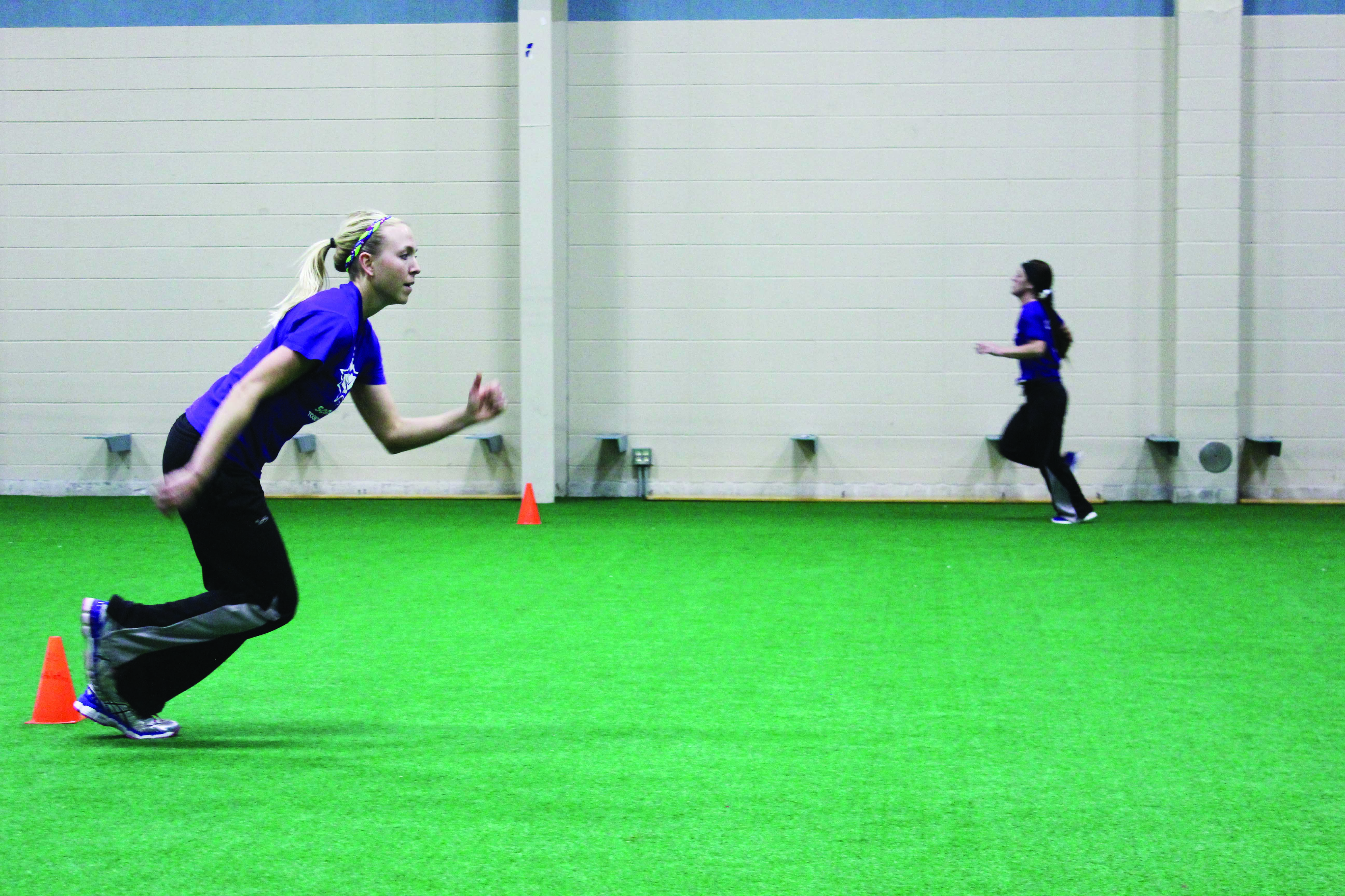 Kourtney Mueller runs in the turf room for softball conditioning