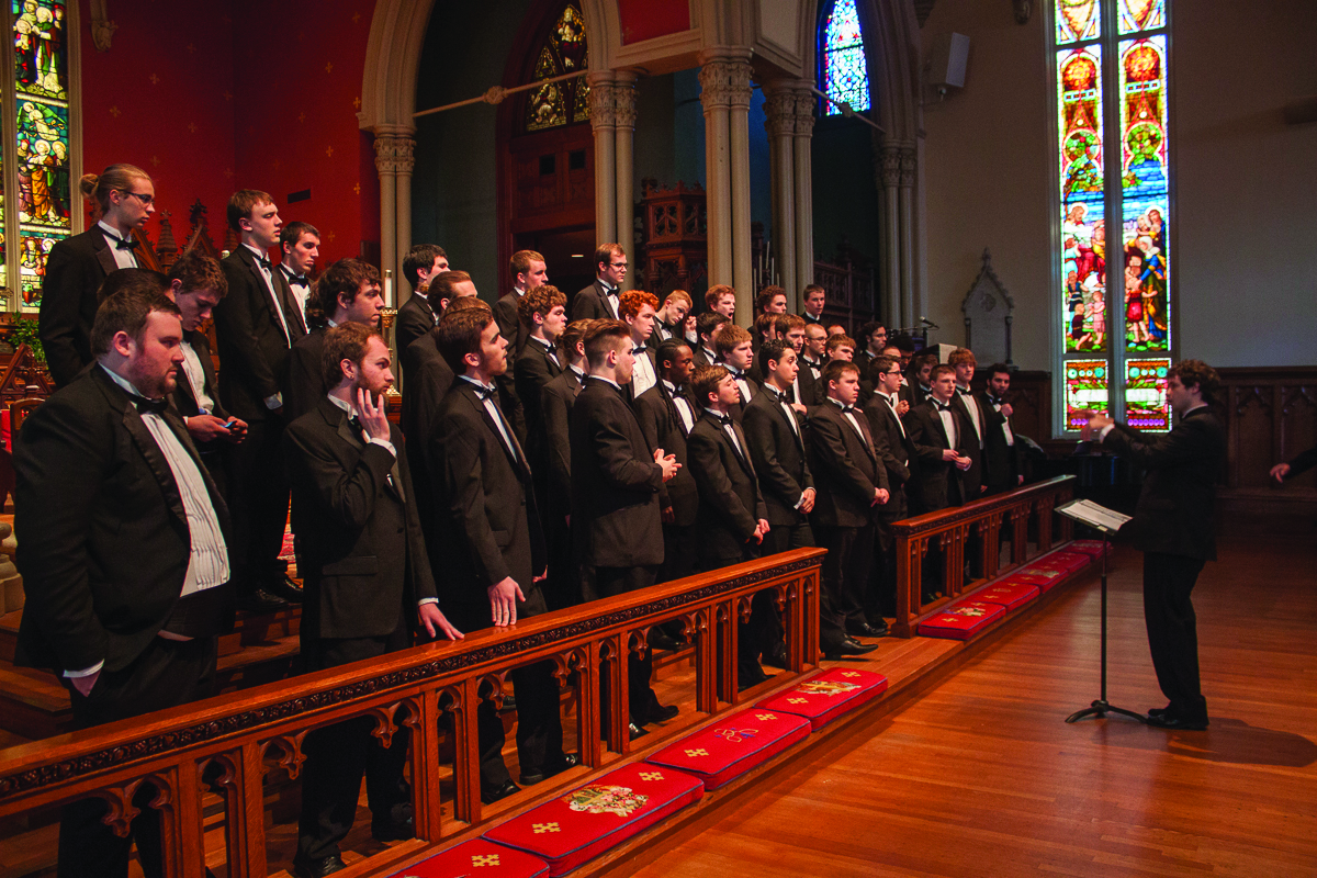 Student Brody Thomas conducts the men's choir during a concert in a church in New Orleans