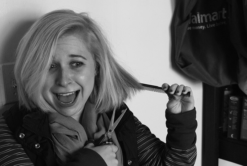 Black and white image of Halle Steingass preparing to cut her hair with scissors