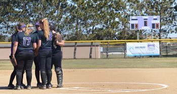 Members of the 2015 softball team meet at the pitcher's mound before a home game. Photo contributed by GoLeafs.net