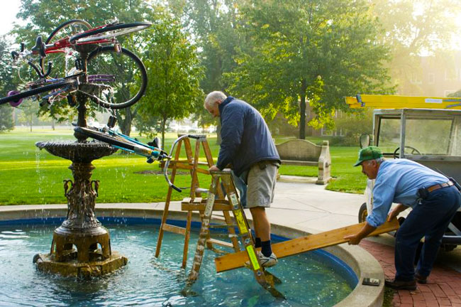 Bicycles are stacked on top of the fountain outside the dining hall