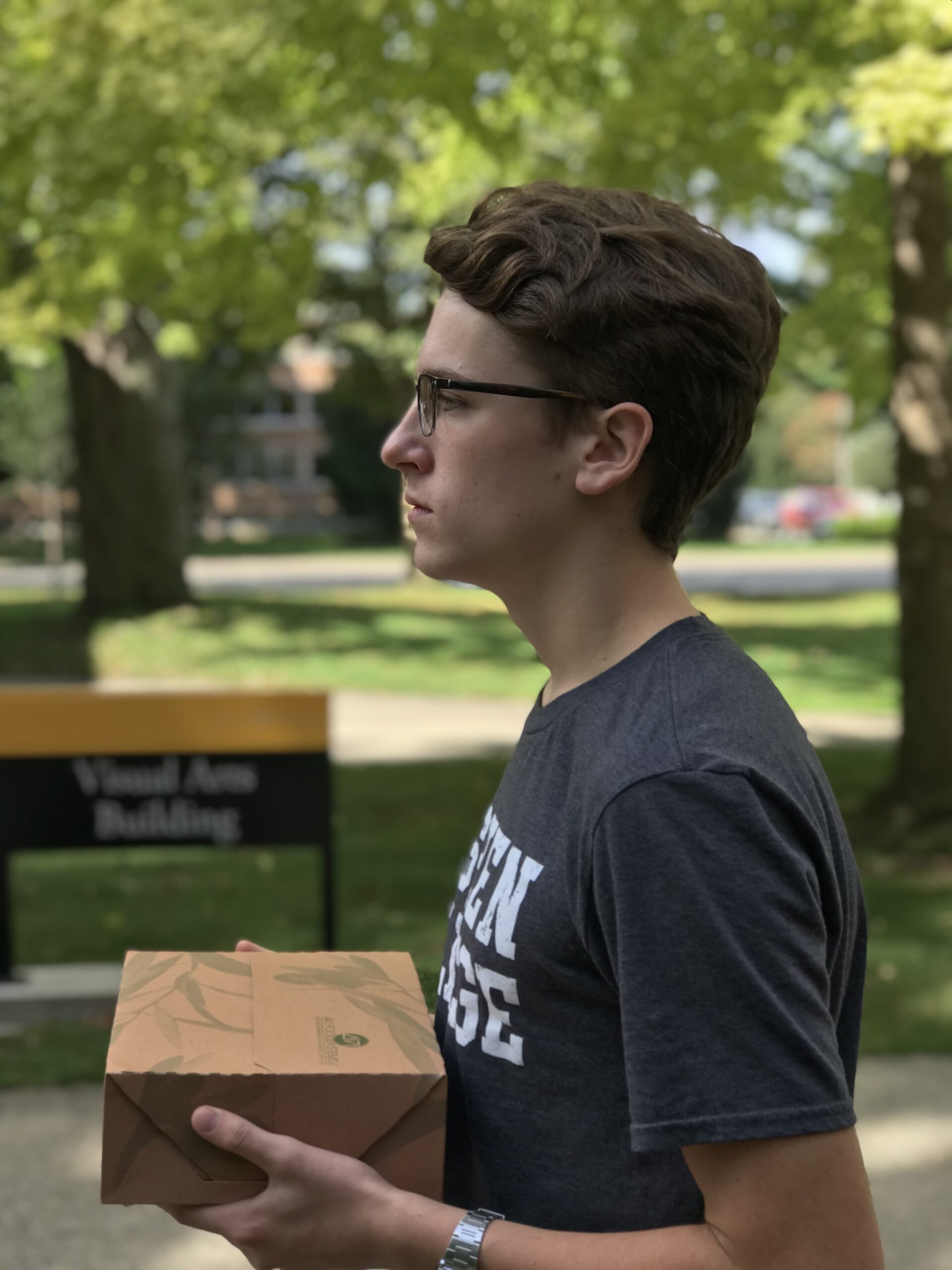Nathan Pauls walks mournfully across campus with his boxed lunch