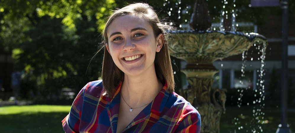 Headshot of Kristin Troyer in front of the campus fountain