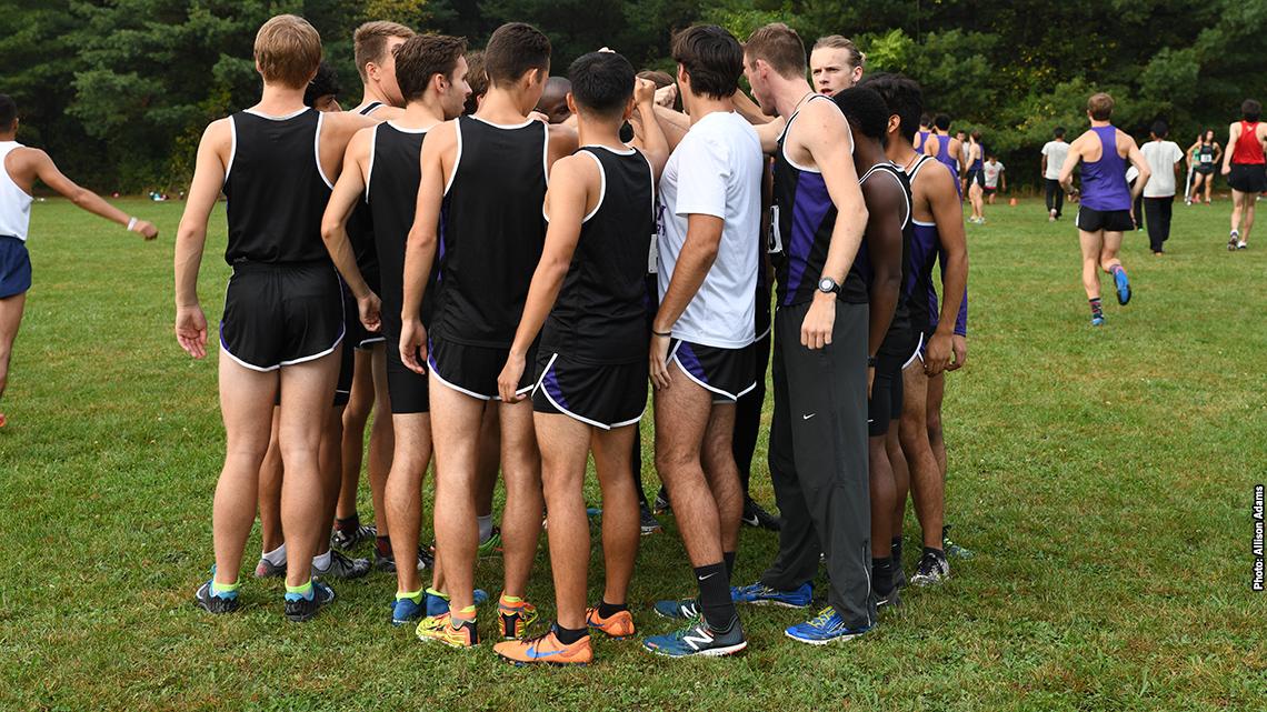 Cross Country team huddles together for a cheer