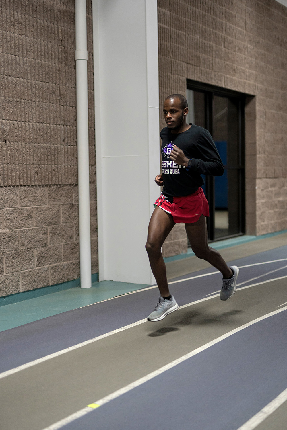 Vincent Kibunja runs on indoor track