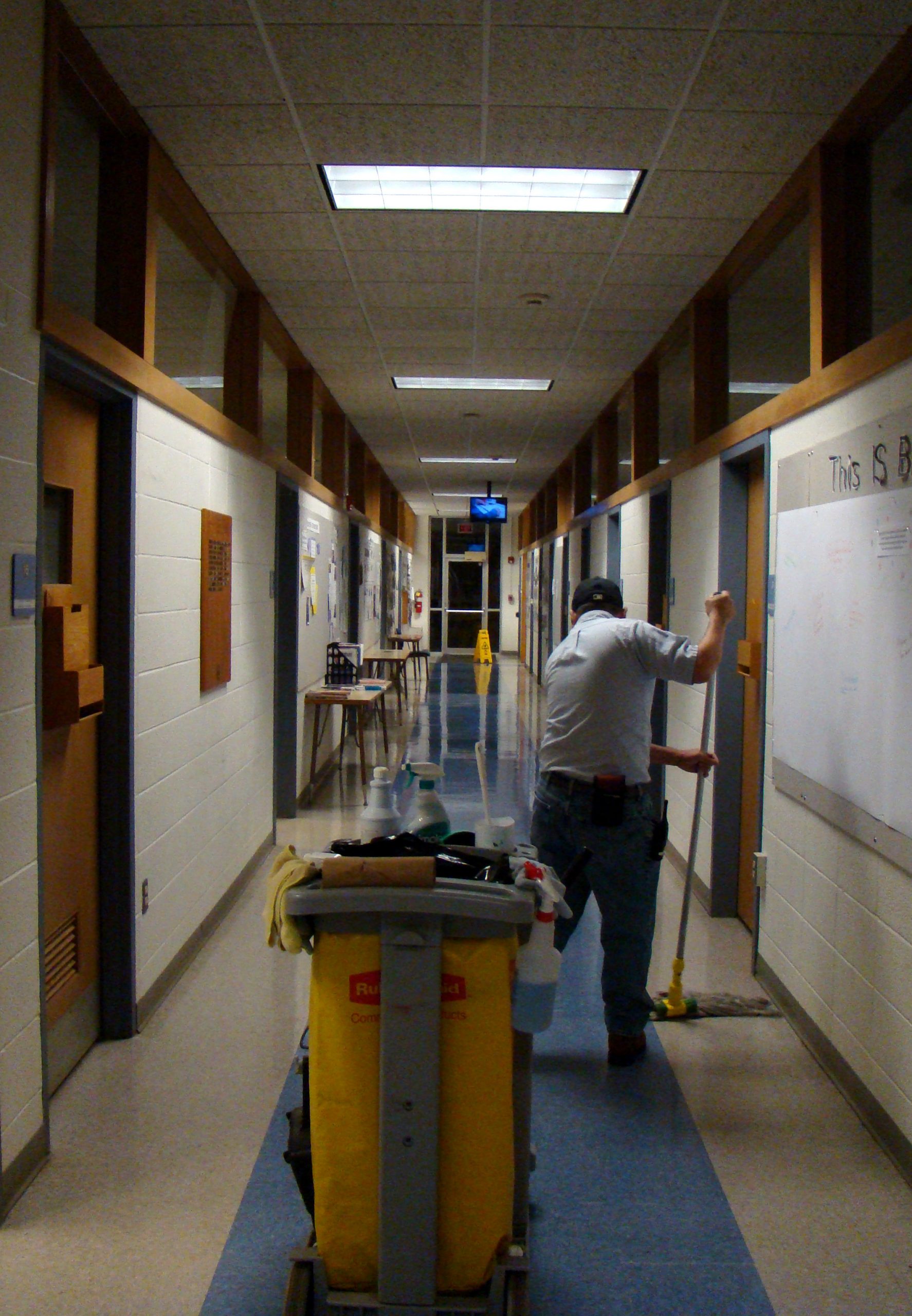 Custodian mopping Newcomer hallway