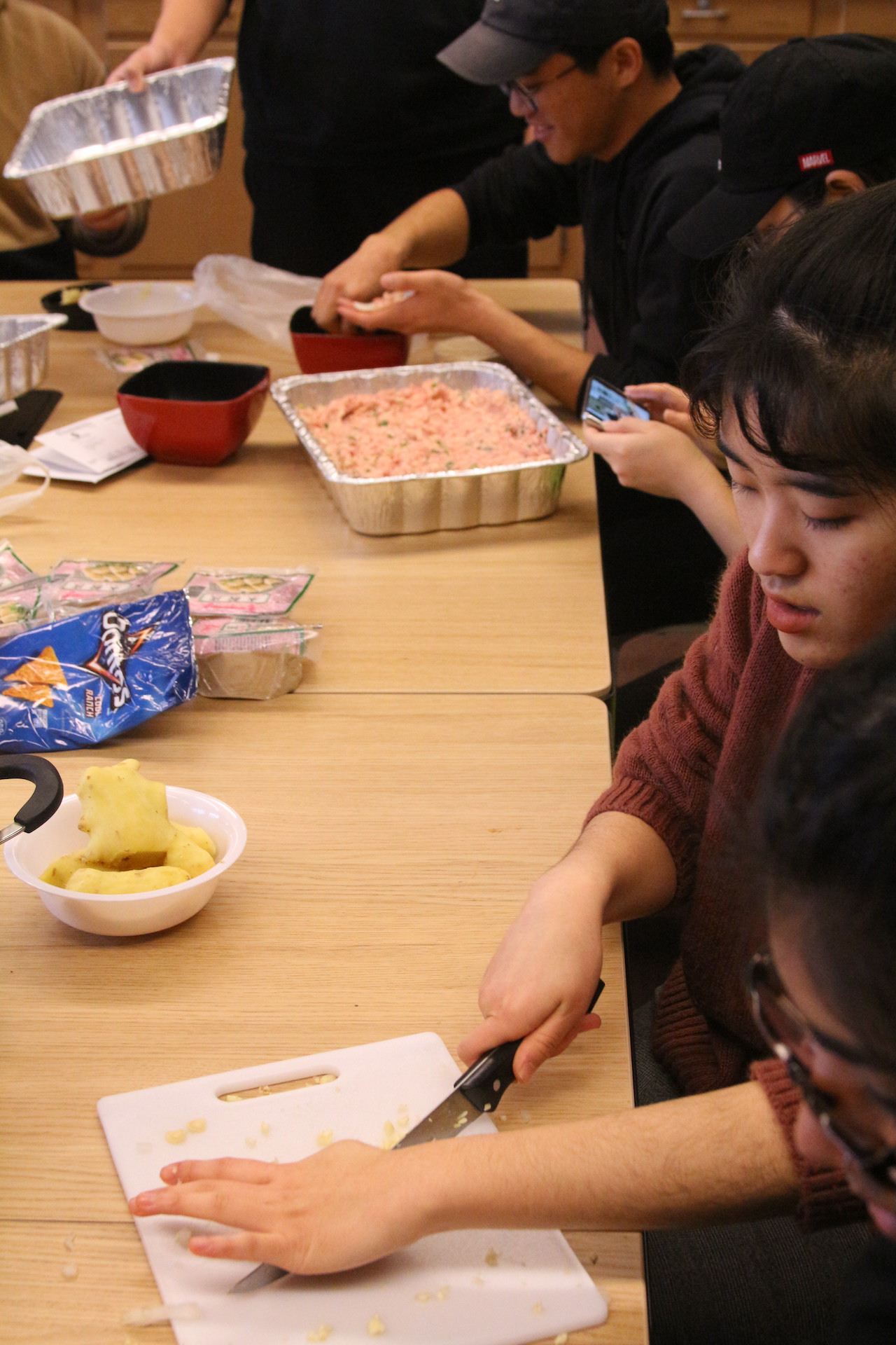 Dali Rodriguez and other students chop up ingredients for dumplings