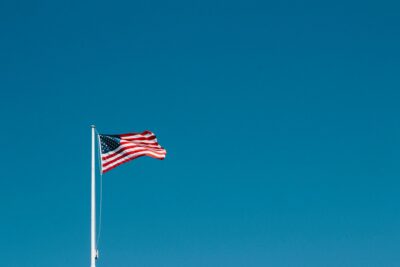 Photo of American flag with wide open blue sky in the background