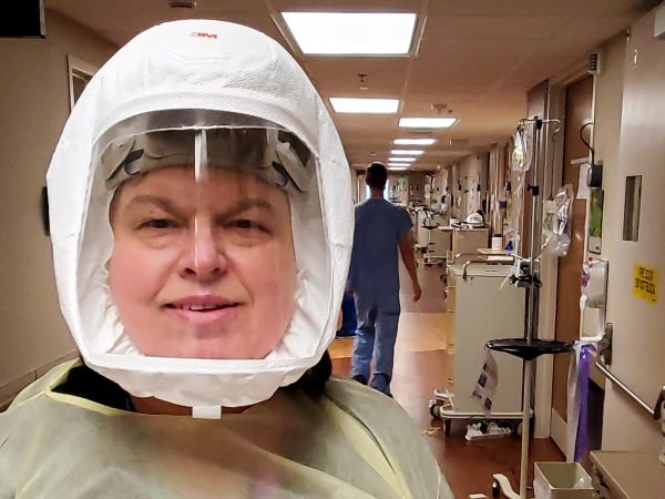 A hospital worker takes a selfie in protective gear