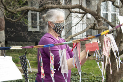 Barbara Gingerich hangs handmade masks on the communal clothesline outside her house