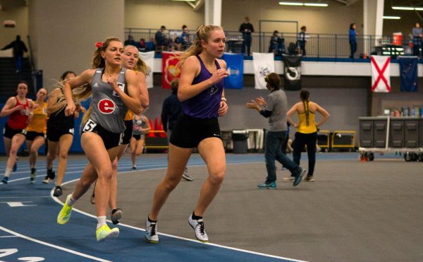 Annika Fisher runs around indoor track