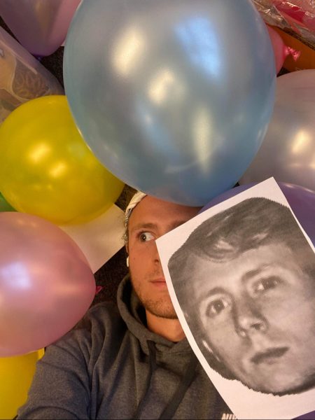 Tanner Pinks hides under a pile of balloons in Nyce's office.