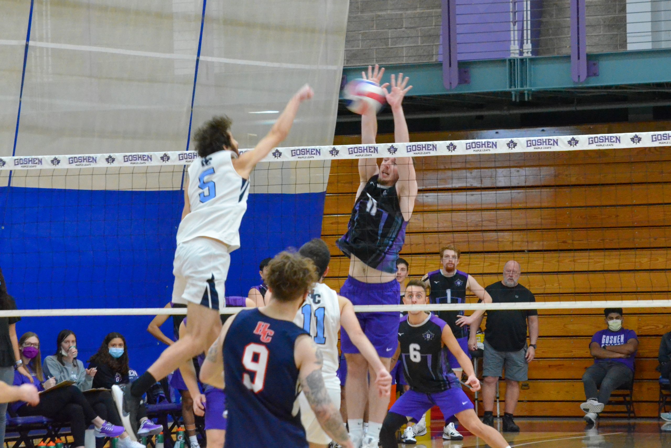 A Goshen student on the men's volleyball blocks a play during a game.