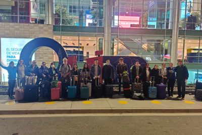 A group of SST students poses with their luggage for a picture outside the airport.