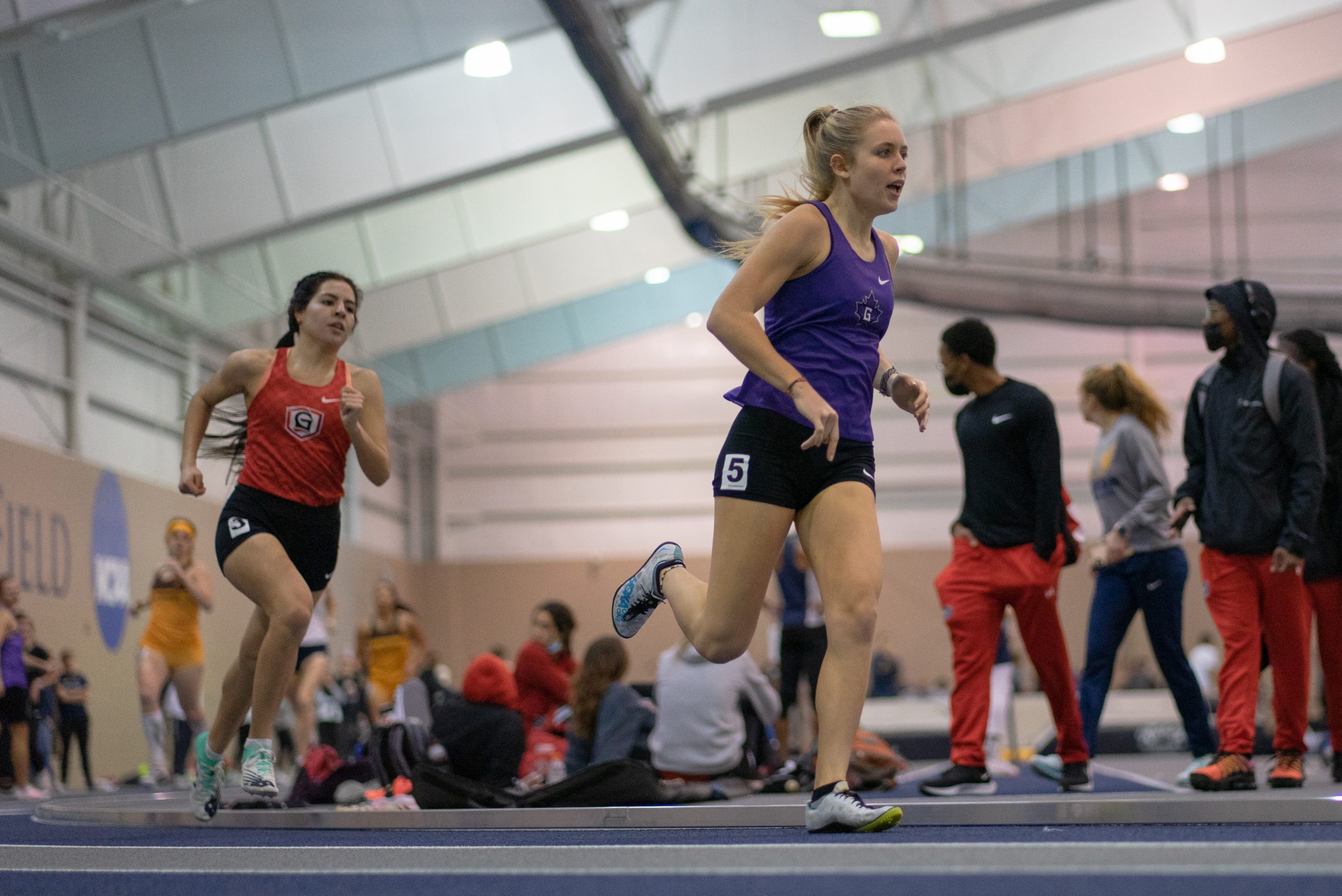 Annika Alderfer Fisher runs around the track at an indoor meet.