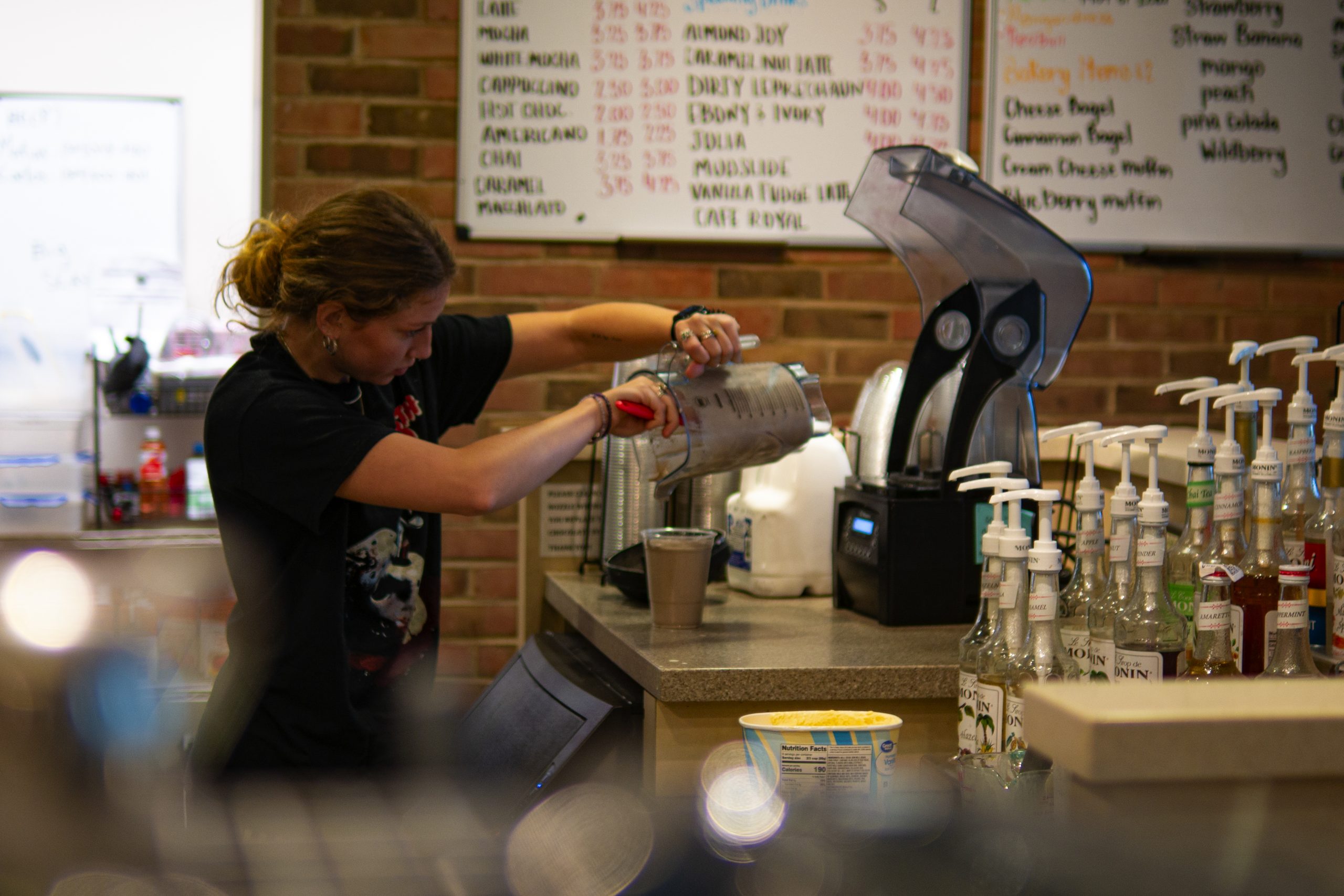 A Java Junction barista scrapes the remains of a milkshake out of a blender during a shift